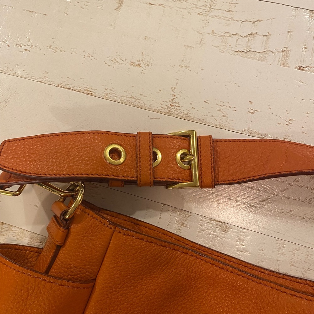 Prada orange bag with authenticity card.